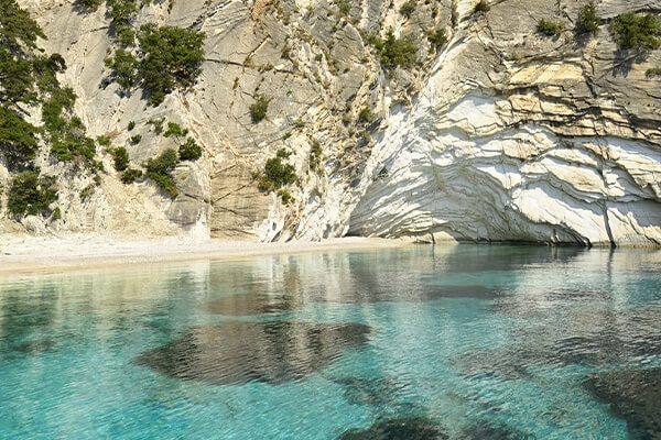 The dramatic white cliffs and secluded beach of Atokos island.